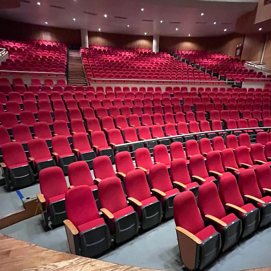 Μεγάλη θεατρική αίθουσα με σειρές κόκκινων καθισμάτων